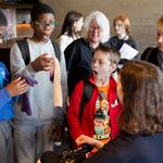 Young person touching costume gloves during The Witches schools touch tour