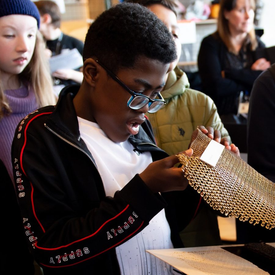 2024-The WitchesTouch-NatalieMitchell-chainmail2000x1000 Young person touching costume chainmail during The Witches schools touch tour