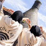 A group of individuals wearing beige hoodies, with the word 