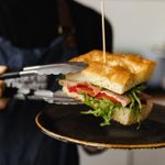 Focaccia sandwich being put on a plate in the Atrium Cafe