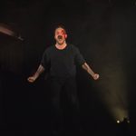 A man stands while screaming and clenching his fists.