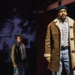 A man in a brown jacket and black beanie is standing with a man wearing a green jacket standing behind him.