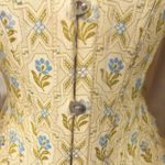 A corset type top made from patterned fabric and with metal fasteners.