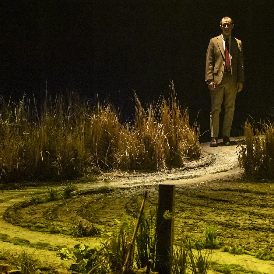 dancing-at-lughnasa-2000x1000-blog-mastehad-set-design-sustainability The set of Dancing at Lughnasa: A lush green field with a winding path. On the horizon stands a man, wearing a suit.