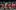 Dear-England-PROD-5833-scaled-aspect-ratio-2000-1000 A group of men are in a group, they all wear red England kit and are in various stages of celebration after a goal. Some are on their knees, all are exclaiming. One of the men is in a green goalie uniform.