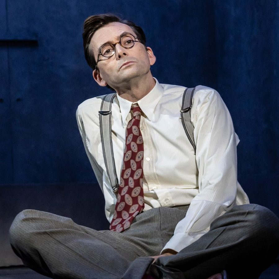 GOOD 2000x1000 David Tennant sitting on the floor, wearing glasses, shirt, tie, braces and trousers.