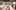 22YoungProds-grafittiws-groupshot A group of people in white hazmat suits holding up graffiti artwork they have produced