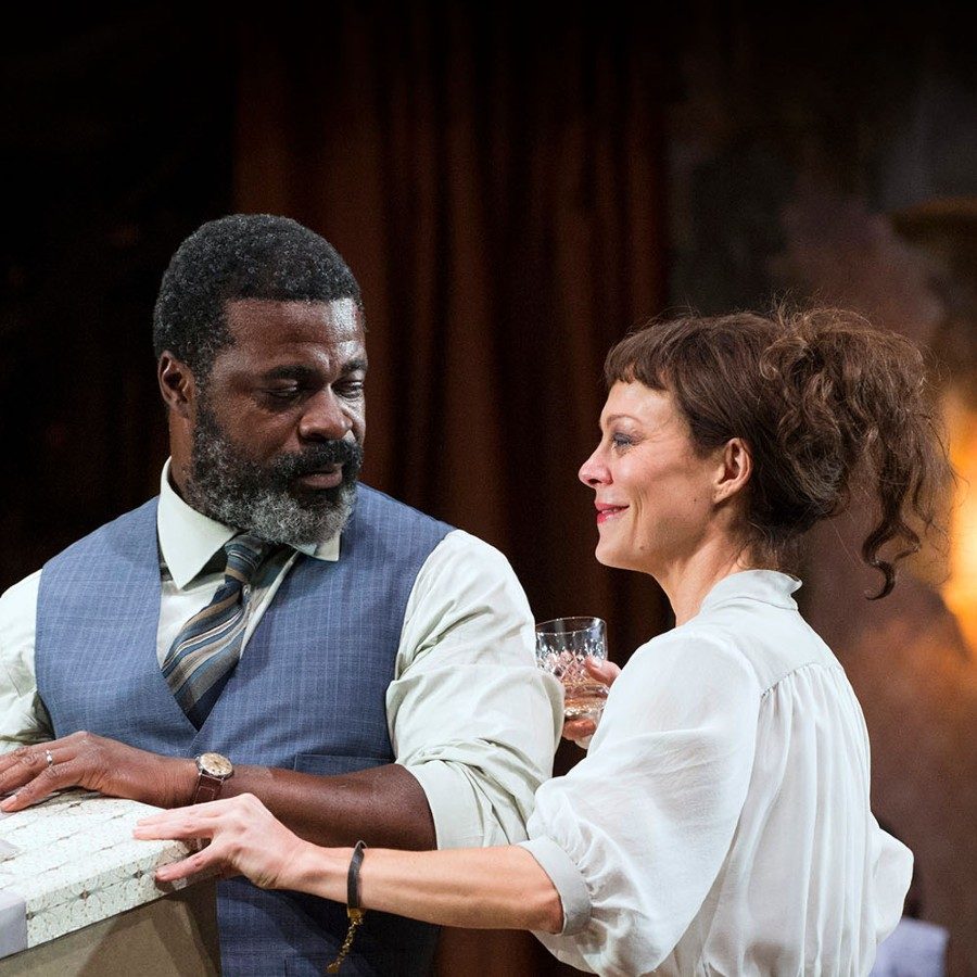 Medea-2014-PRO-16-Richard-Hubert-Smith-2000x1000 Helen McCrory and Danny Sapani in the National Theatre production of Medea, 2014. McCrory and Sapani are smiling and holding a large boxed gift.