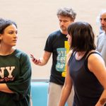 Four actors in rehearsals, all wearing casual clothes. They all have concerned expressions and are looking to each other.