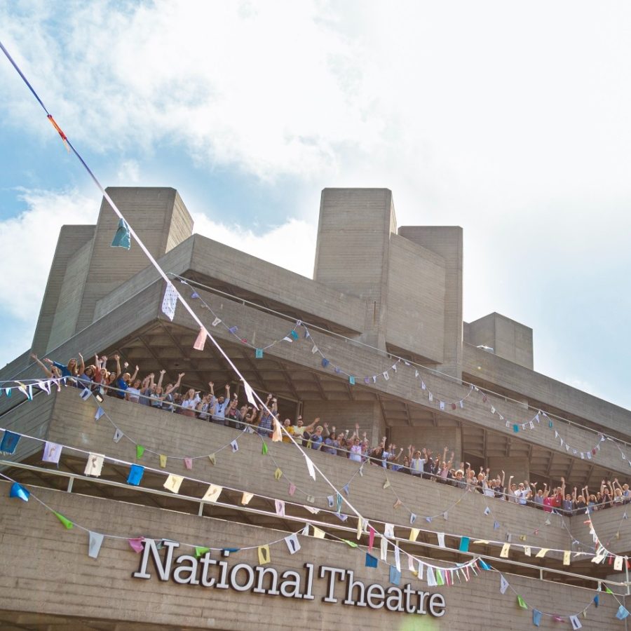 NT Building Fly The Flag 1x1.33 landscape The National Theatre building with crowds waving on the upper terrace and bunting hung on three terraces