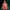 Nye-Take-Your-Seats-National-Theatre-1080x1080 A person (Michael Sheen) wearing a striped pajamas stands against a bold, dark green and black gradient background, looking upward with a thoughtful expression.