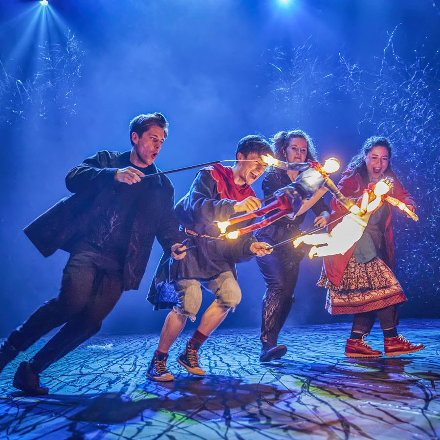 Ocean-at-the-End-of-the-Lane-Puppets-wide-2000x1000-Brinkhoff-Moegenburg Domonic Ramsden and Keir Oglivy (Boy), operating two illuminated stick puppets, as Aimee McGolderick and Millie Hikasa (Lettie) look on, laughing
