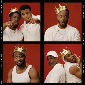 The-Hot-Wing-King-National-Theatre-mobile-v2 A collage of four photos featuring six men against a red background. In the top-left, two men pose with one pointing forward. In the top-right, another man wearing a crown makes a surprised face. The bottom-right shows two men back-to-back, and the bottom-left features a man with a crown looking up. All are wearing white clothes.