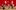 The-Motive-and-the-Cue-Cast-1-West-End-Photo-Mark-Douet A group of people are having a party in a large room with red panelled walls and cream furniture and floor. Some are standing, some sit on the sofa and chairs and some lie or kneel on the floor. There are two large bunches of white balloons.